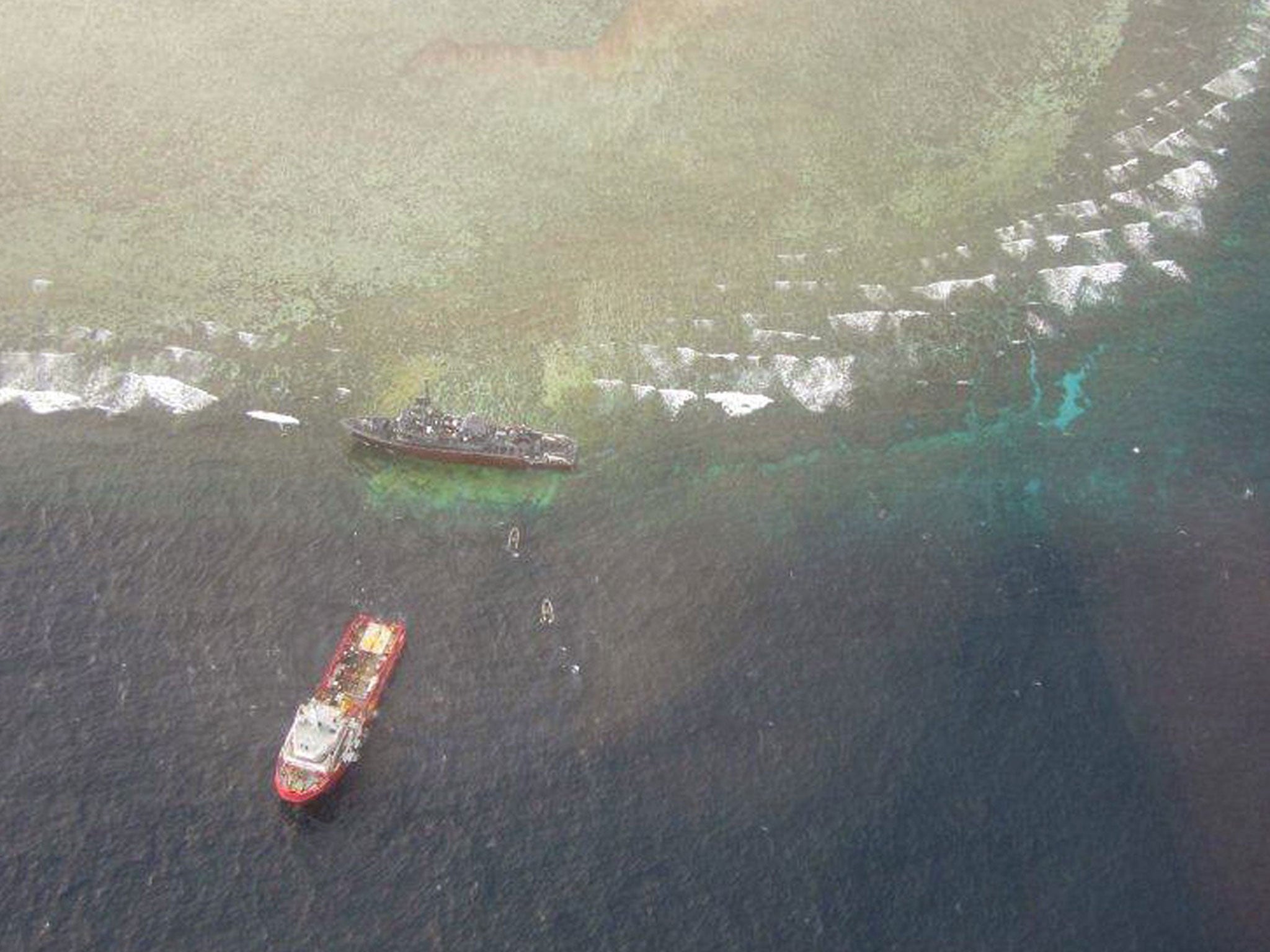 The USS Guardian (R) at the Tubbataha reef after it ran aground, in western island of Palawan, while another US vessel stands by. The US Navy will have to break it into pieces and then move it