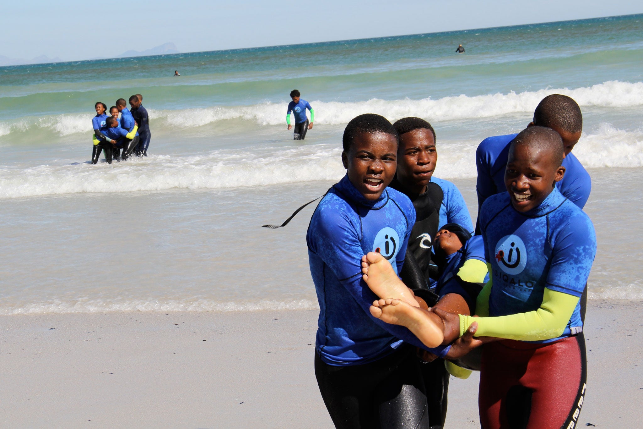Participants from the Waves for Change programme, a surfing and HIV educational programme founded by the author, perform the "Stigma Lift": an adapted lifesaving exercise which teaches about the negative impact of discrimination against those living with HIV.