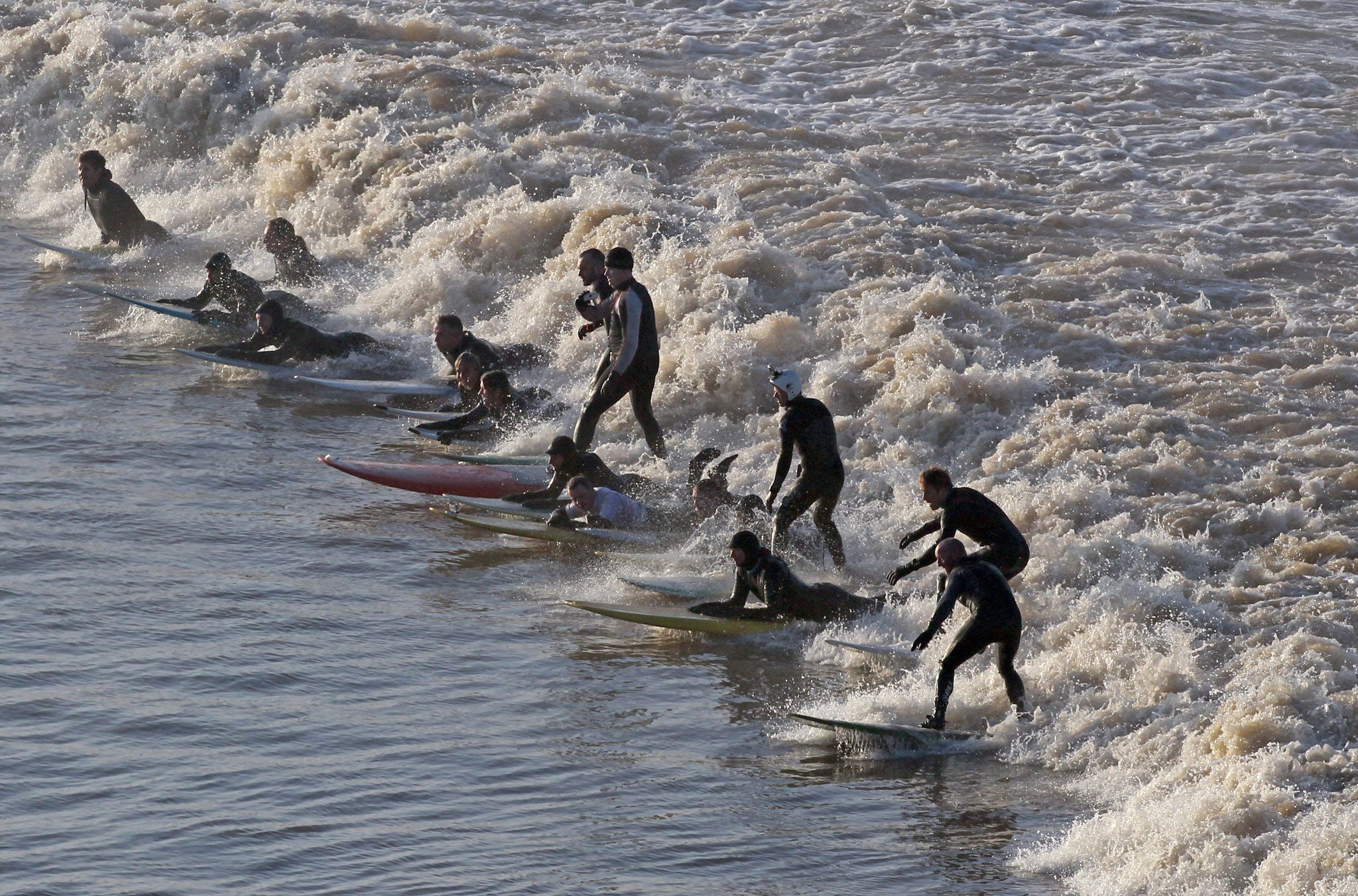On the crest: Surfers take on the Severn Bore - which can reach speeds of up to 10mph and creates waves of up to 2m