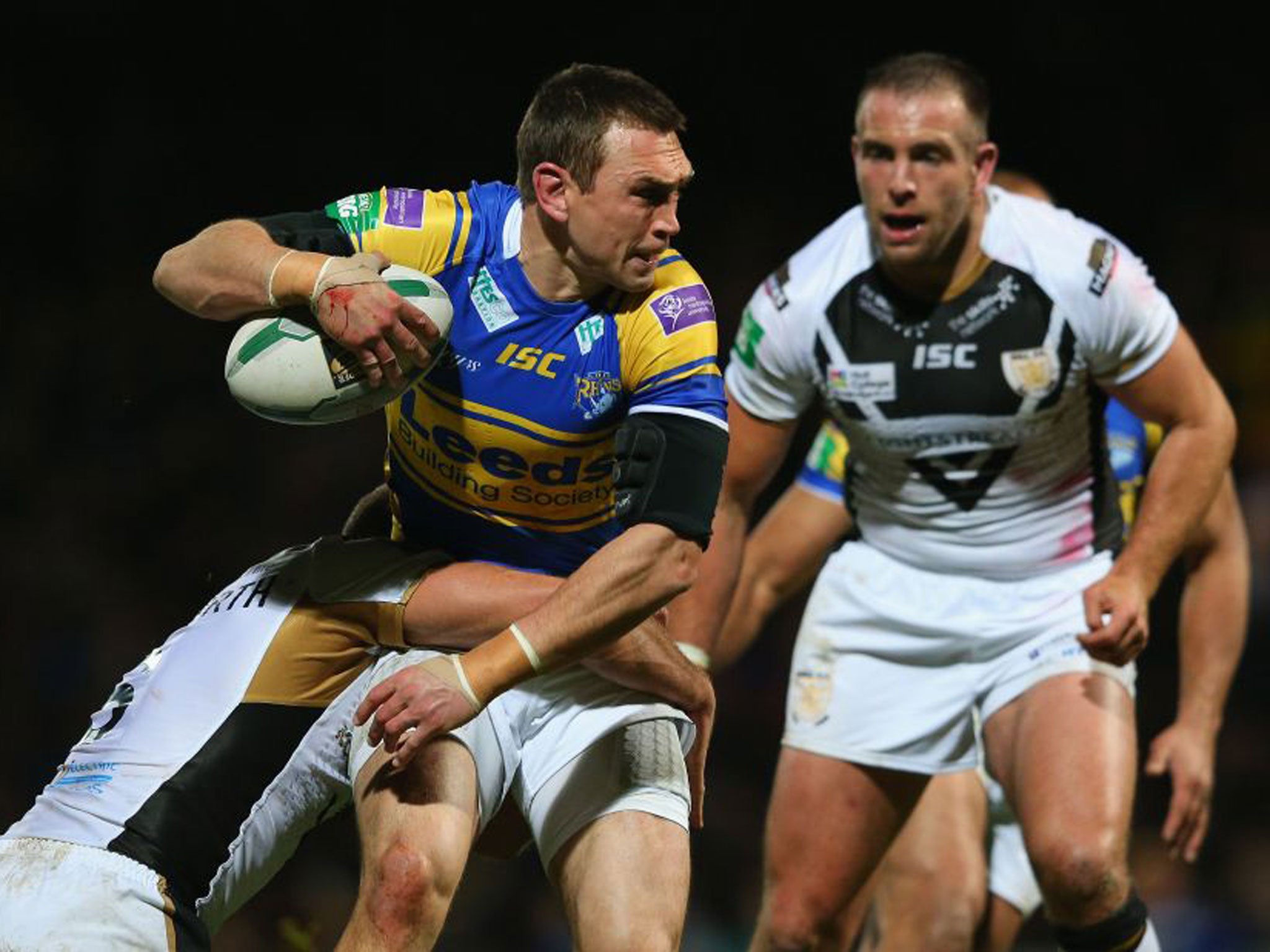 Leeds’ Kevin Sinfield (left) is tackled by Hull’s Daniel Holdsworth