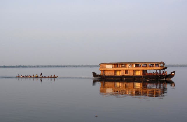Go with flow: A houseboat tows a fishing boat on Lake Vembanadu in Kerala