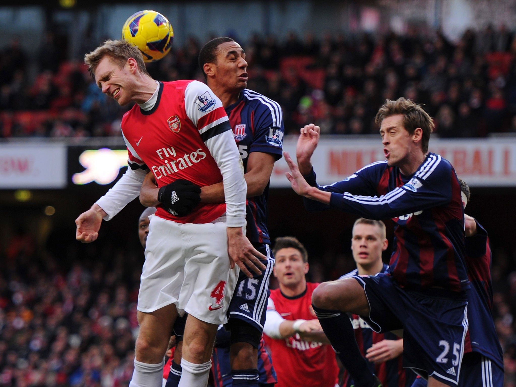 Per Mertesacker of Arsenal competes for the ball against Steven N'Zonzi and Peter Crouch