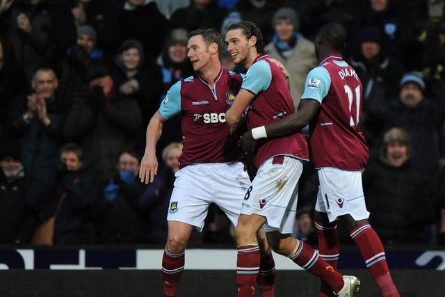 Andy Carroll (C) of West Ham United celebrates scoring the first and only goal of the game with Kevin Nolan (L) and Mohamed Diame