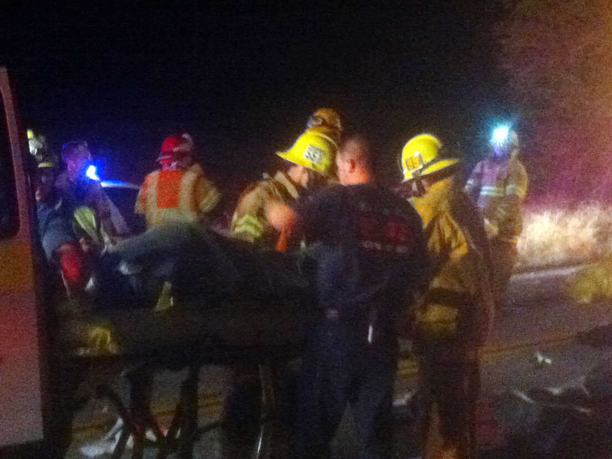Emergency personnel assist victims at the scene of the bus crash near Forest Falls