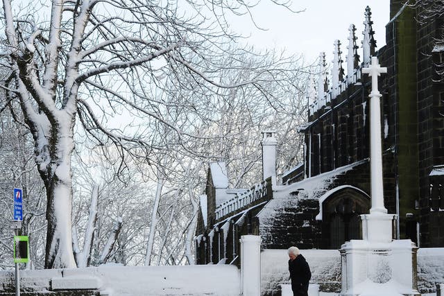A woman makes her way past the St John the Baptist Church in Penistone, South Yorkshire, as parts of Britain brace for a return of snow and gales