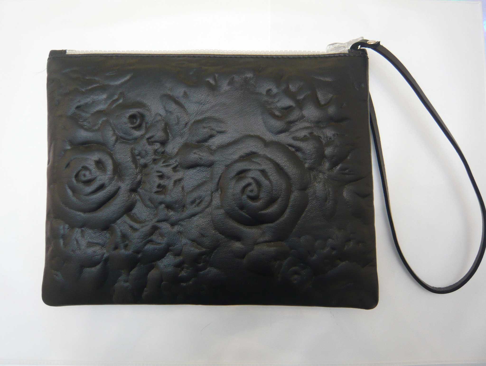 Christopher Kane's leather clutch bag is embossed with roses which are only visible when they catch the light