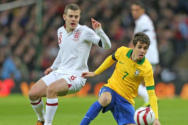 Jack Wilshere (left) and Oscar tussle for the ball at Wembley last night