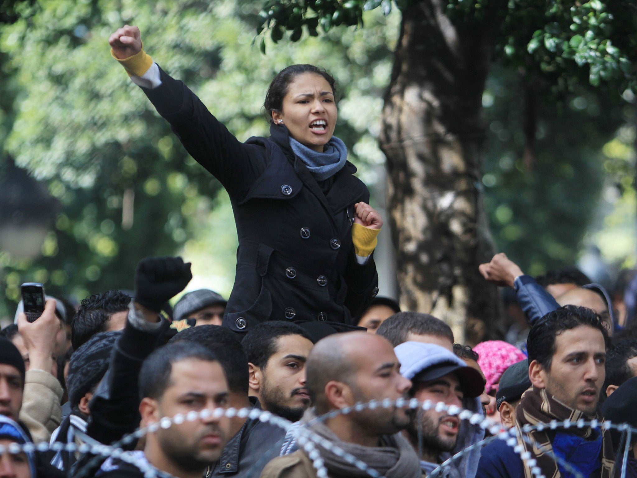A demonstrator raises her fist during a demonstration in Tunis