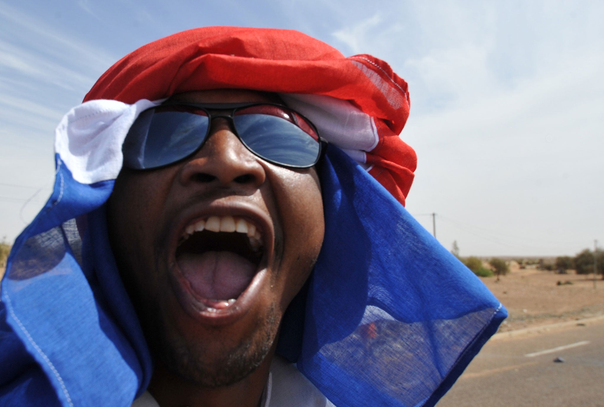 A man in Ansongo on January 29, 2013 cheers the anticipated arrival of troops from Niger.