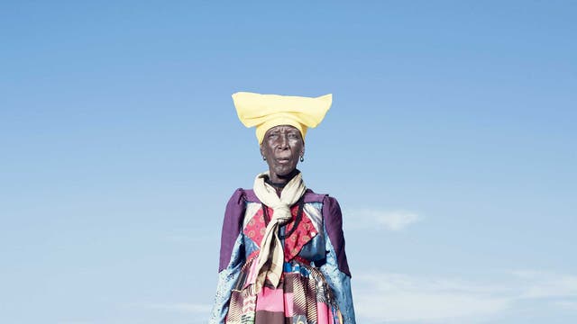 An elderly Herero woman in a patchwork dress that would be worn every day of the year; as Herero women get older,
the 'horns' of their headdresses get smaller. According to some accounts, this symbolises their loss of fertility