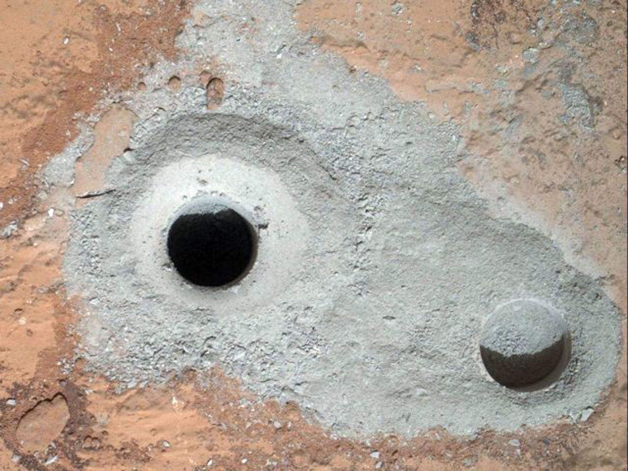 This image released by NASA on Saturday Feb. 9, 2013 shows a fresh drill hole, center, made by the Curiosity rover