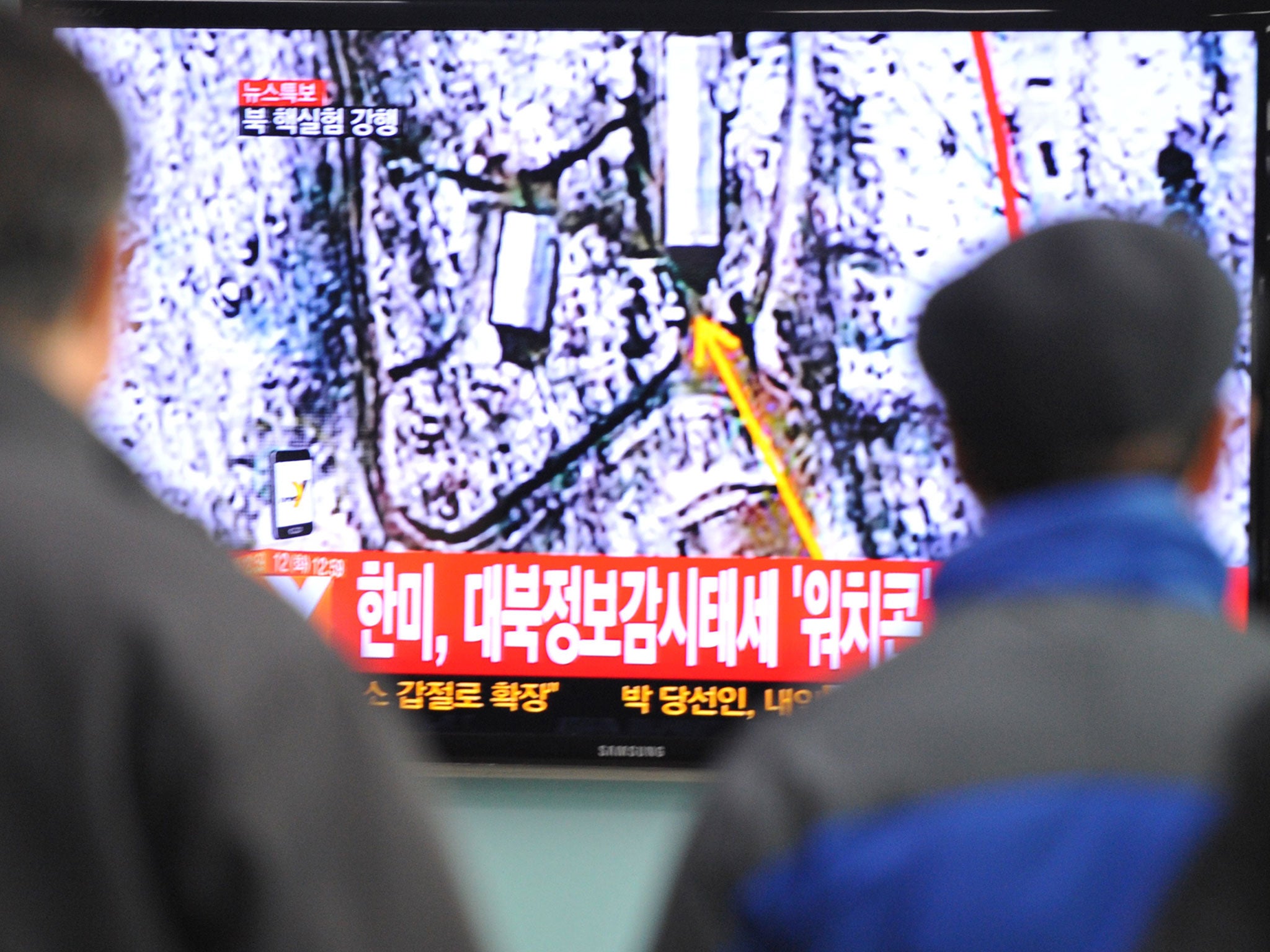 South Korean passengers watch TV news reporting North Korea's apparent nuclear test