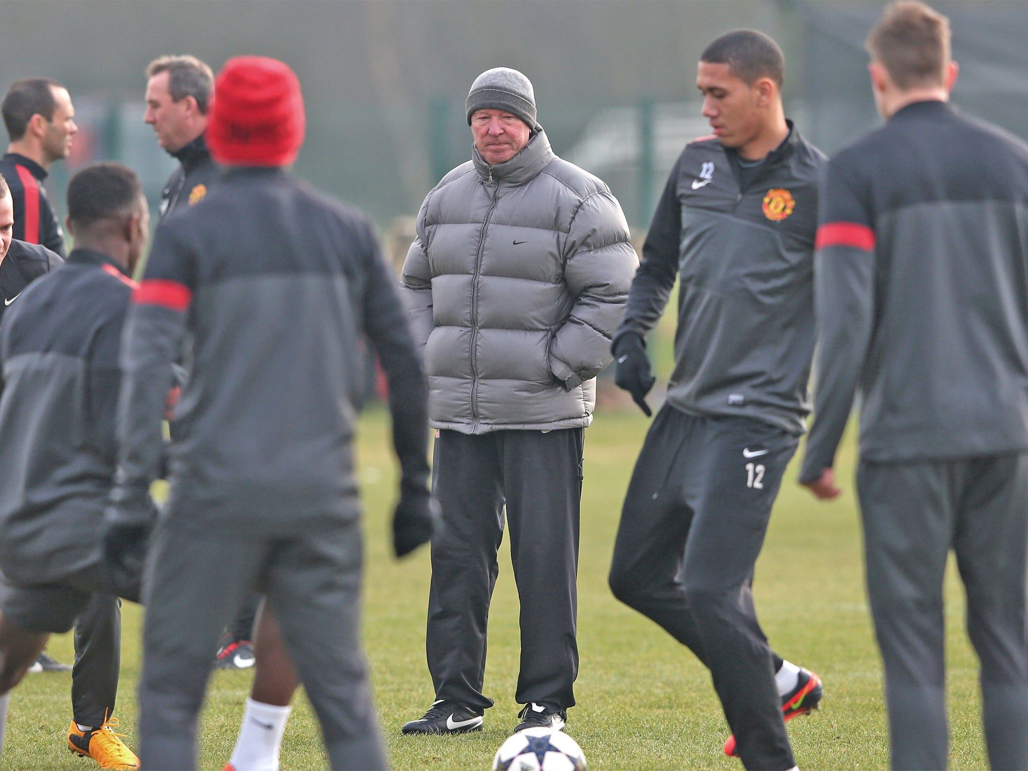 Sir Alex Ferguson keeps on eye on his United players during training yesterday