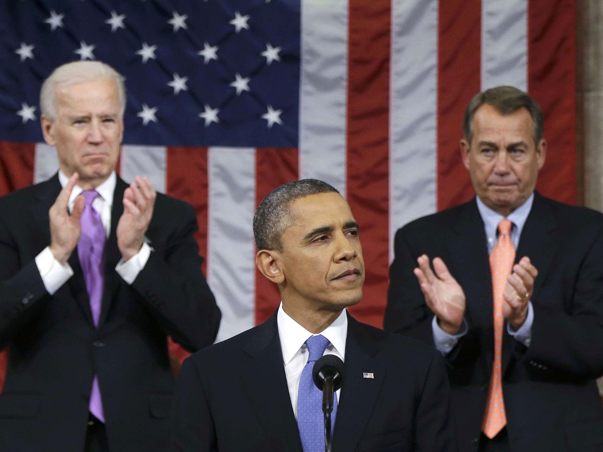 US House Speaker John Boehner (right) and Vice President Joe Biden (left) stand to applaud as President Barack Obama delivers his State of the Union speech