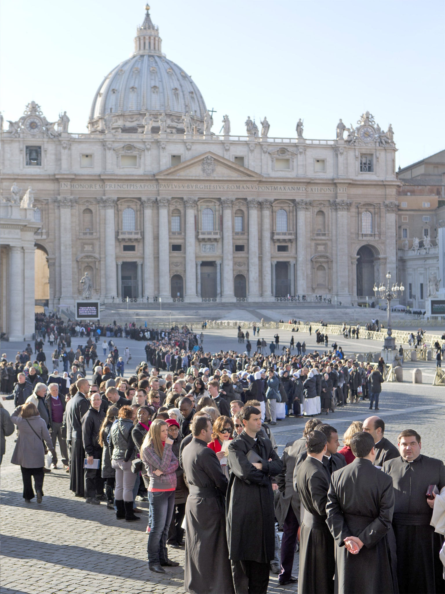 People stand in a line to enter St. Peter's Basilica at the Vatican to attend an Ash Wednesday mass