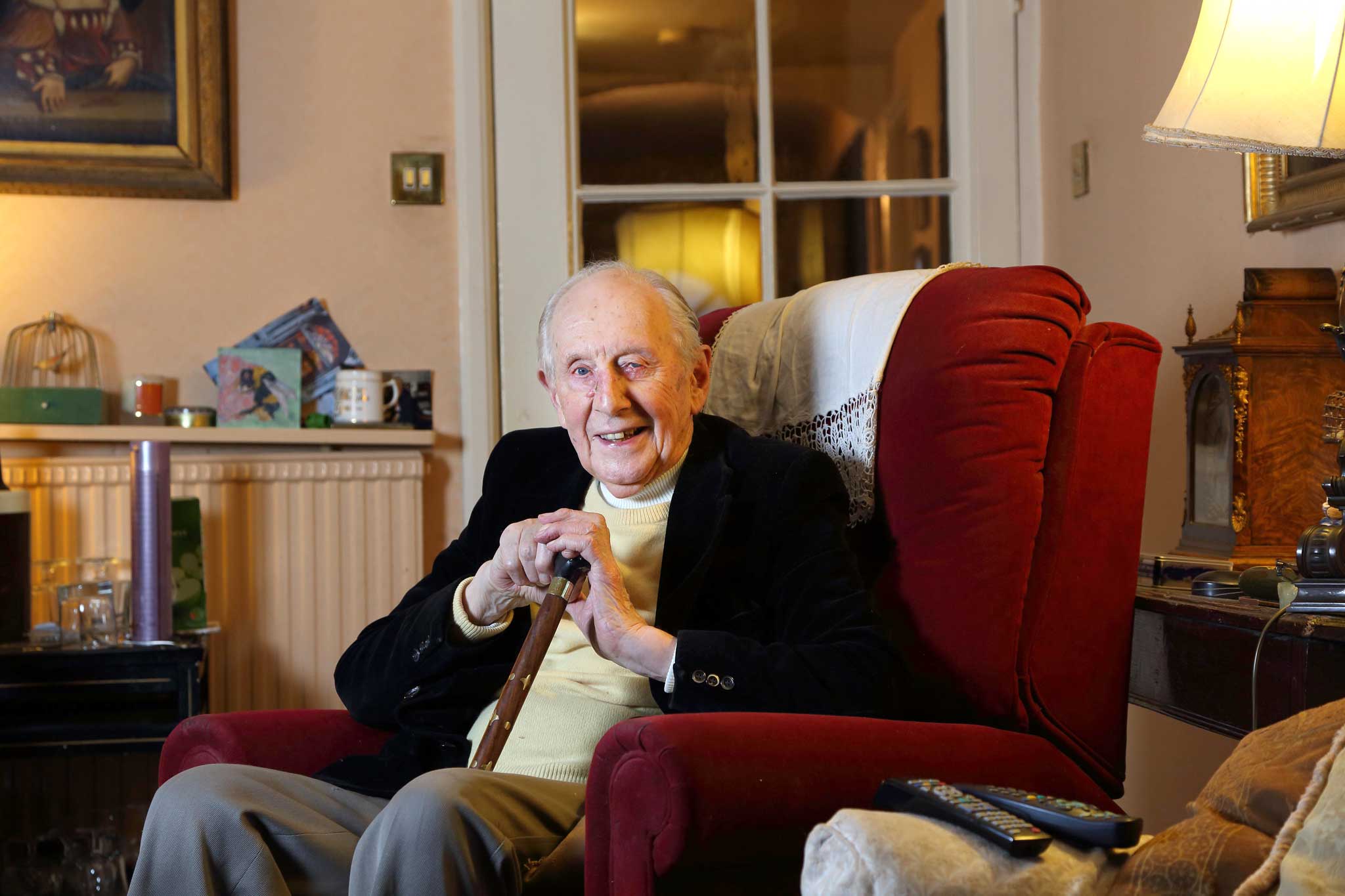Irrepressible: Chapman Pincher in his sitting room, which is decorated wall-to-wall with pictures and trinkets