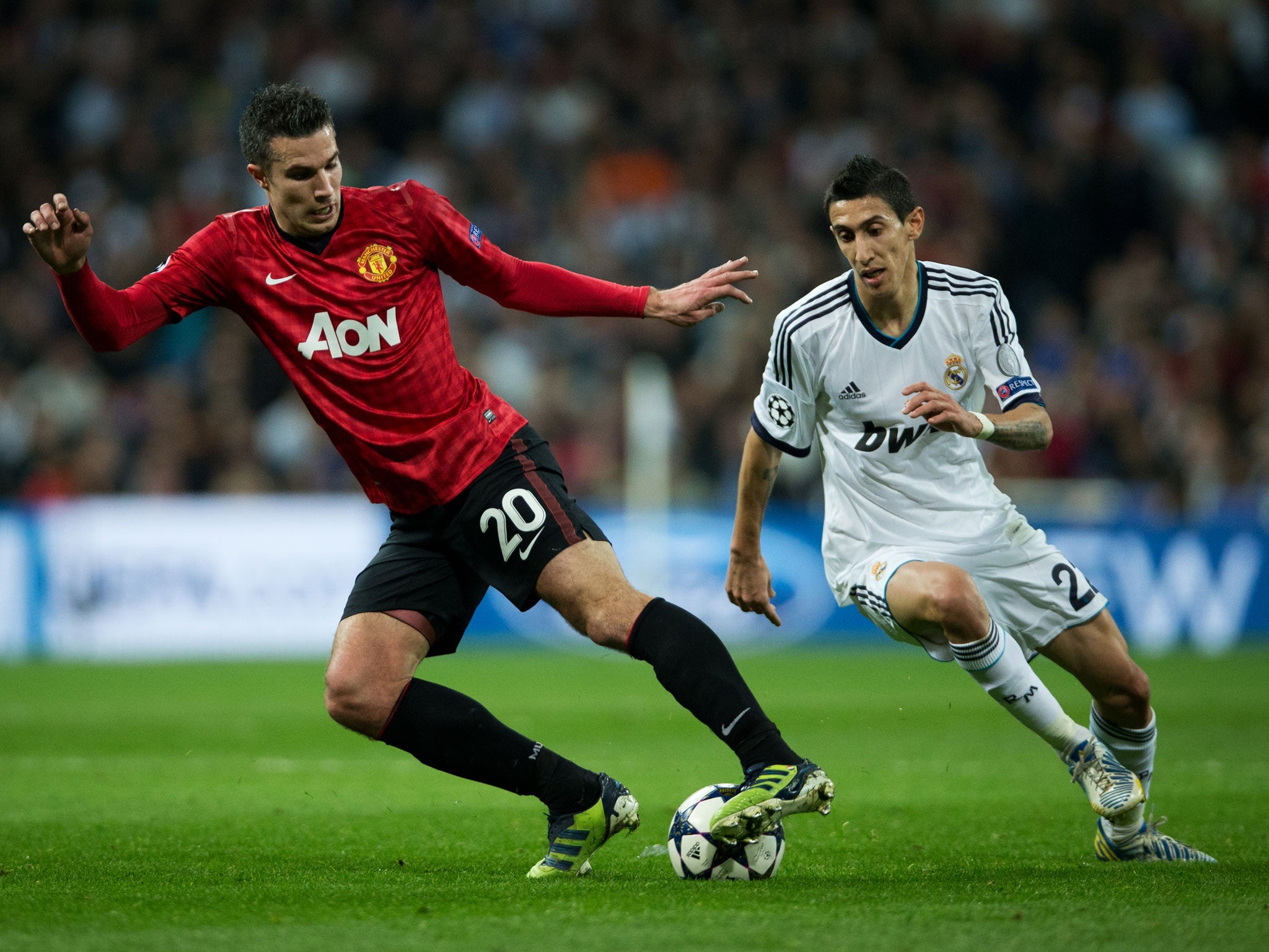 Robin van Persie of Manchester United clashes with Angel Di Maria of Real Madrid
