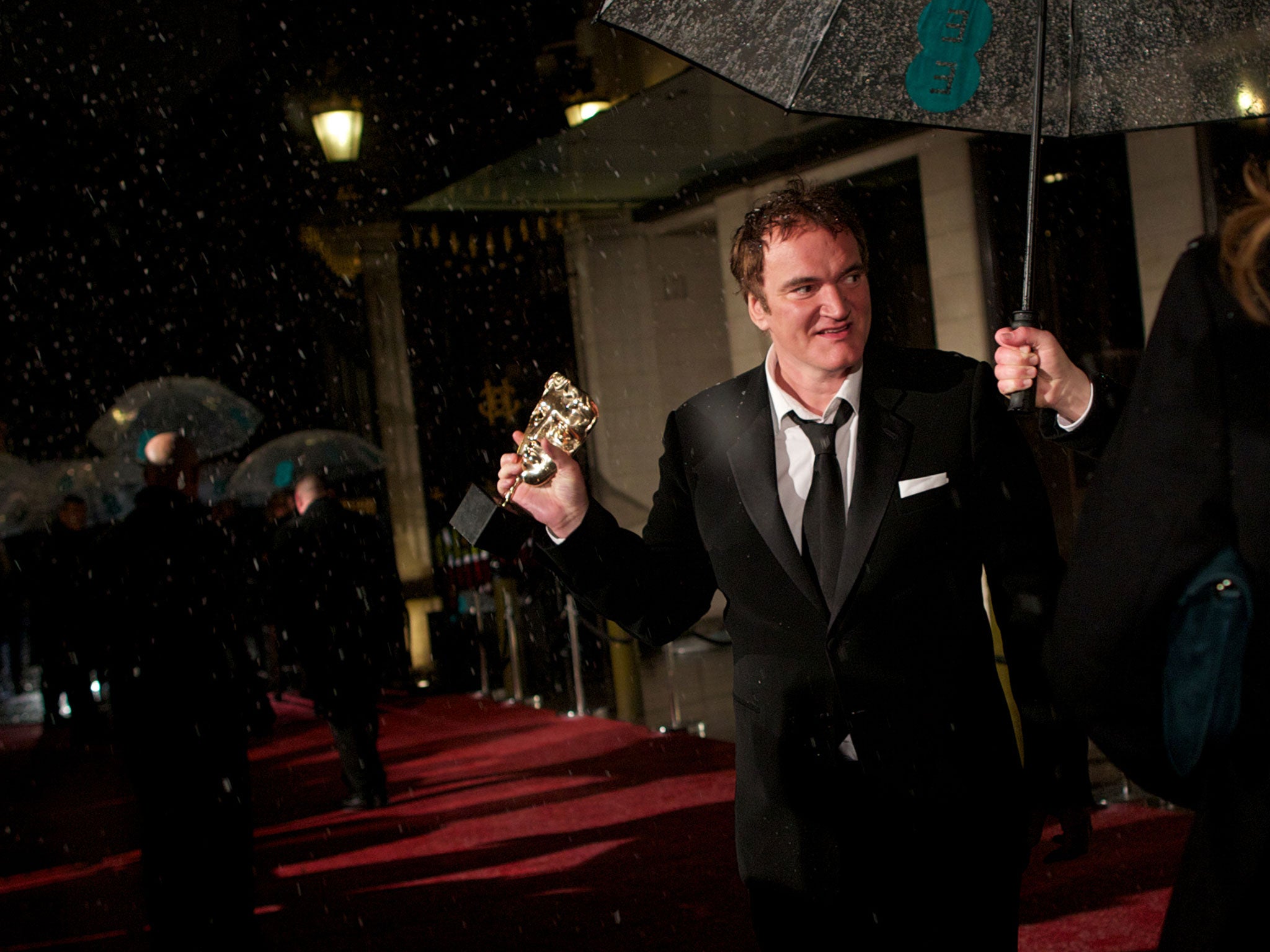 US director Quentin Tarantino holds his award for best original screenplay as he arrives for the BAFTA British Academy Film Awards after party in London on February 10, 2013.