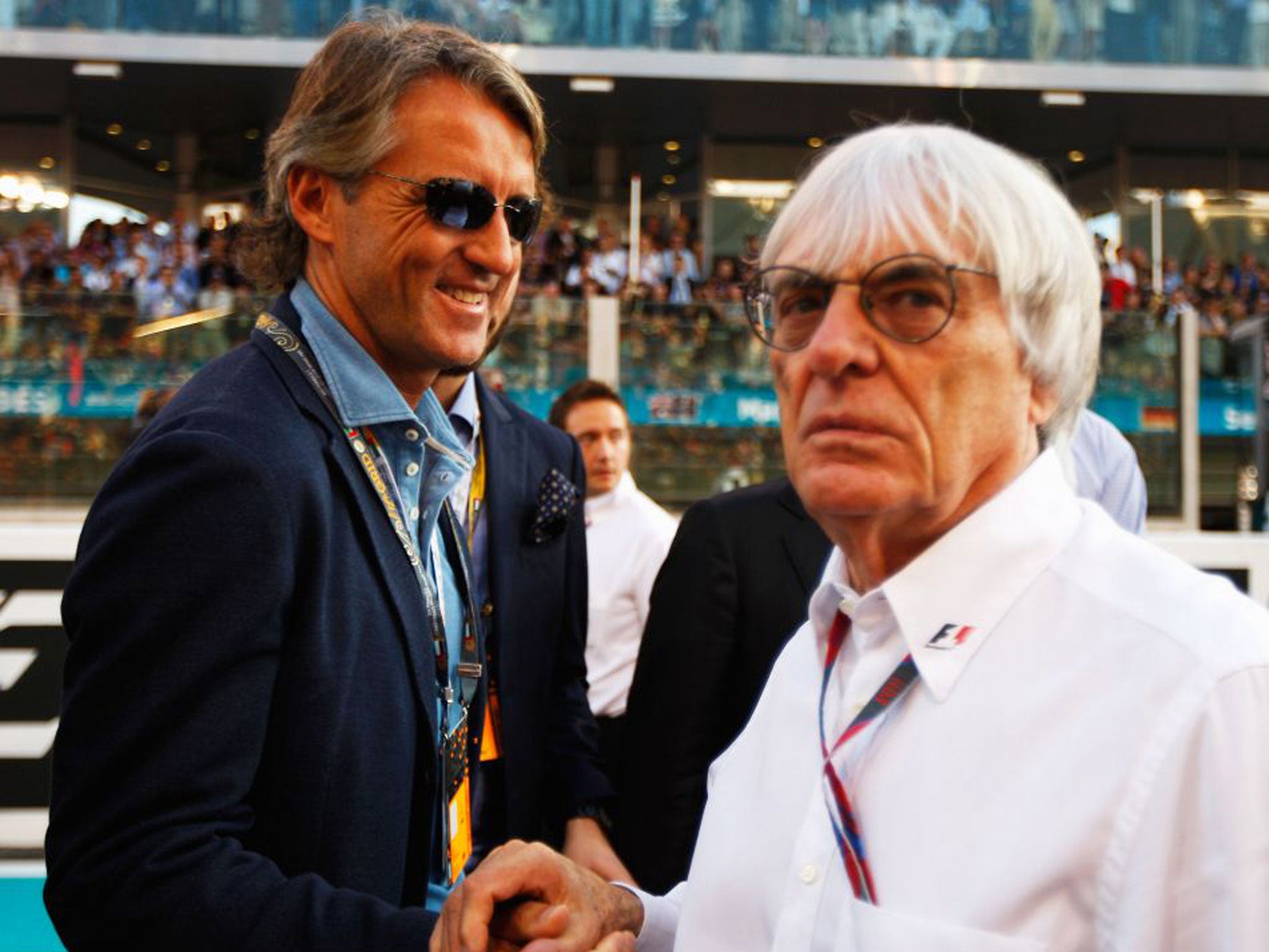 A dapper Roberto Mancini (left) greets Bernie Ecclestone in Dubai