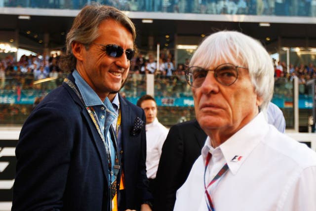 A dapper Roberto Mancini (left) greets Bernie Ecclestone in Dubai 