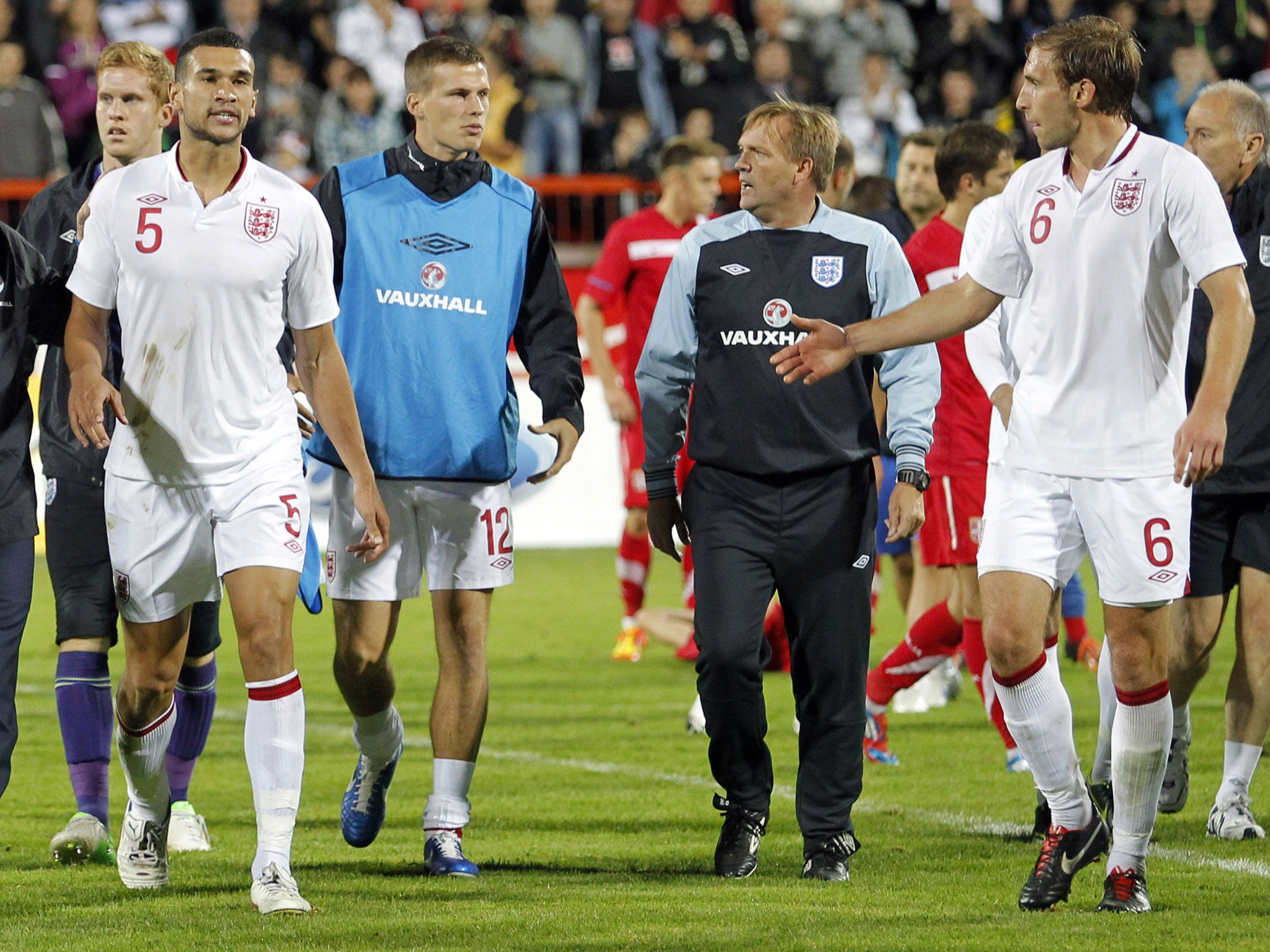 Head Coach Stuart Pearce of England and his assistant Steve Wigley lead Steven Caulker, Craig Dawson, Ryan Bennett and the rest of his team off the pitch