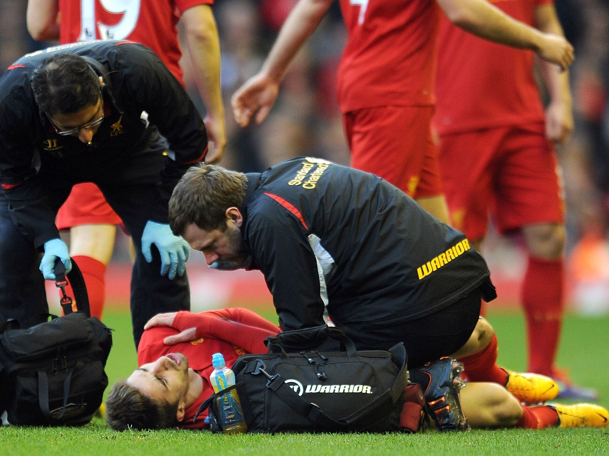 Zaf Iqbal (L) the Liverpool club doctor and Chris Morgan (R) physiotherapist treat Fabio Borini
