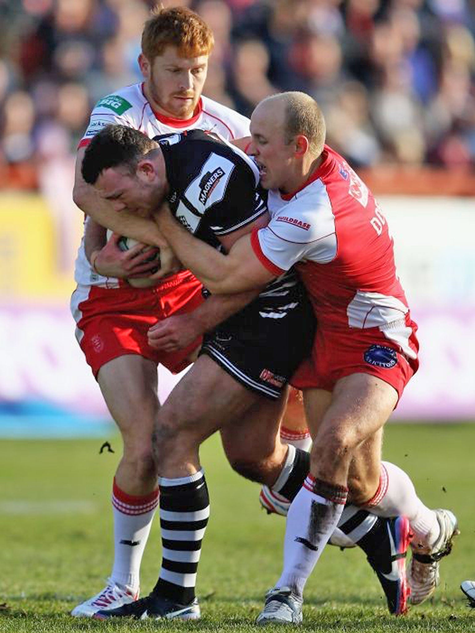 Stefan Marsh, of Widnes, is tackled by Hull KR’s Michael Dobson and Kris Welham