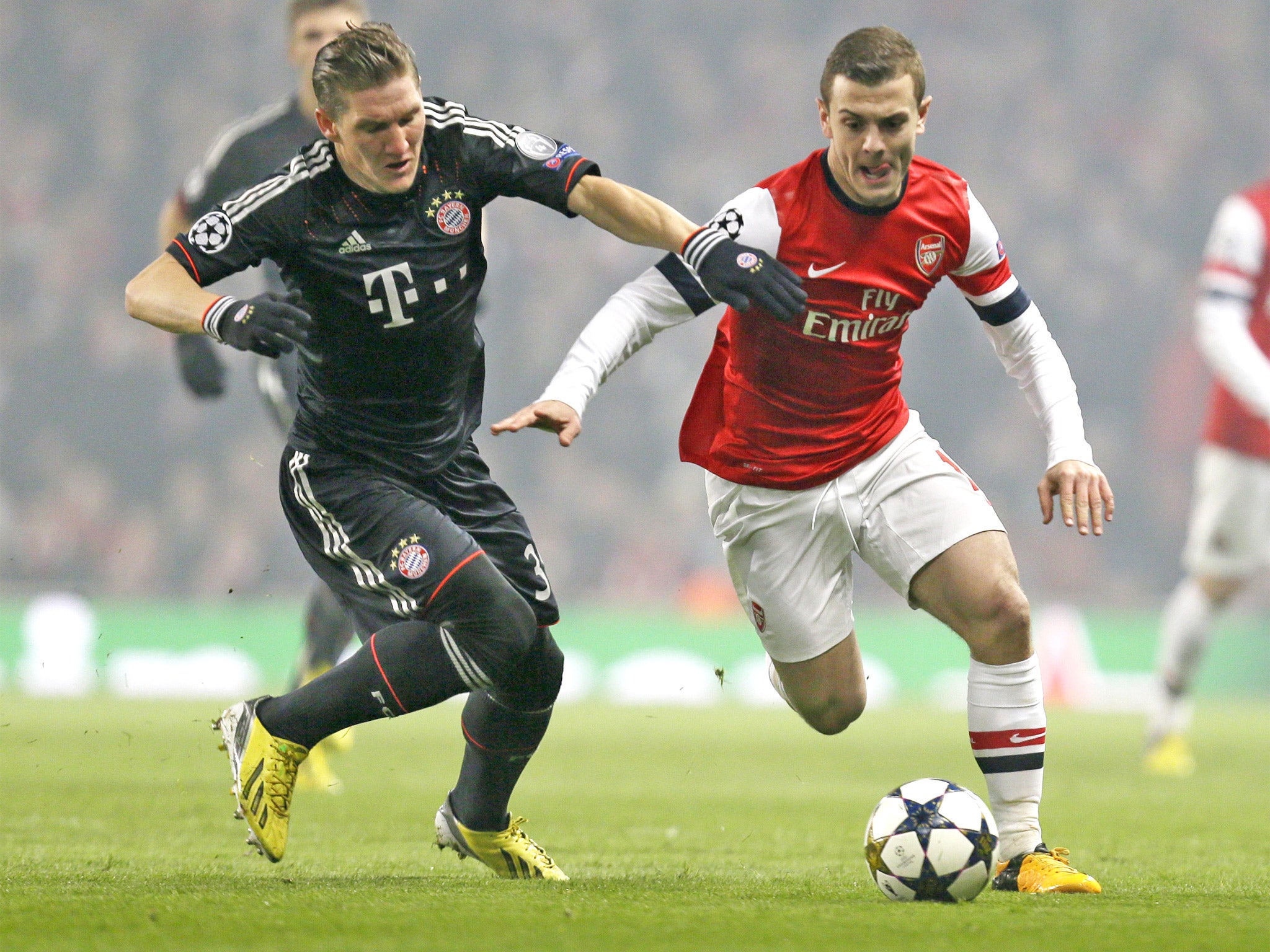 Bastian Schweinsteiger tussles with Jack Wilshere at the Emirates