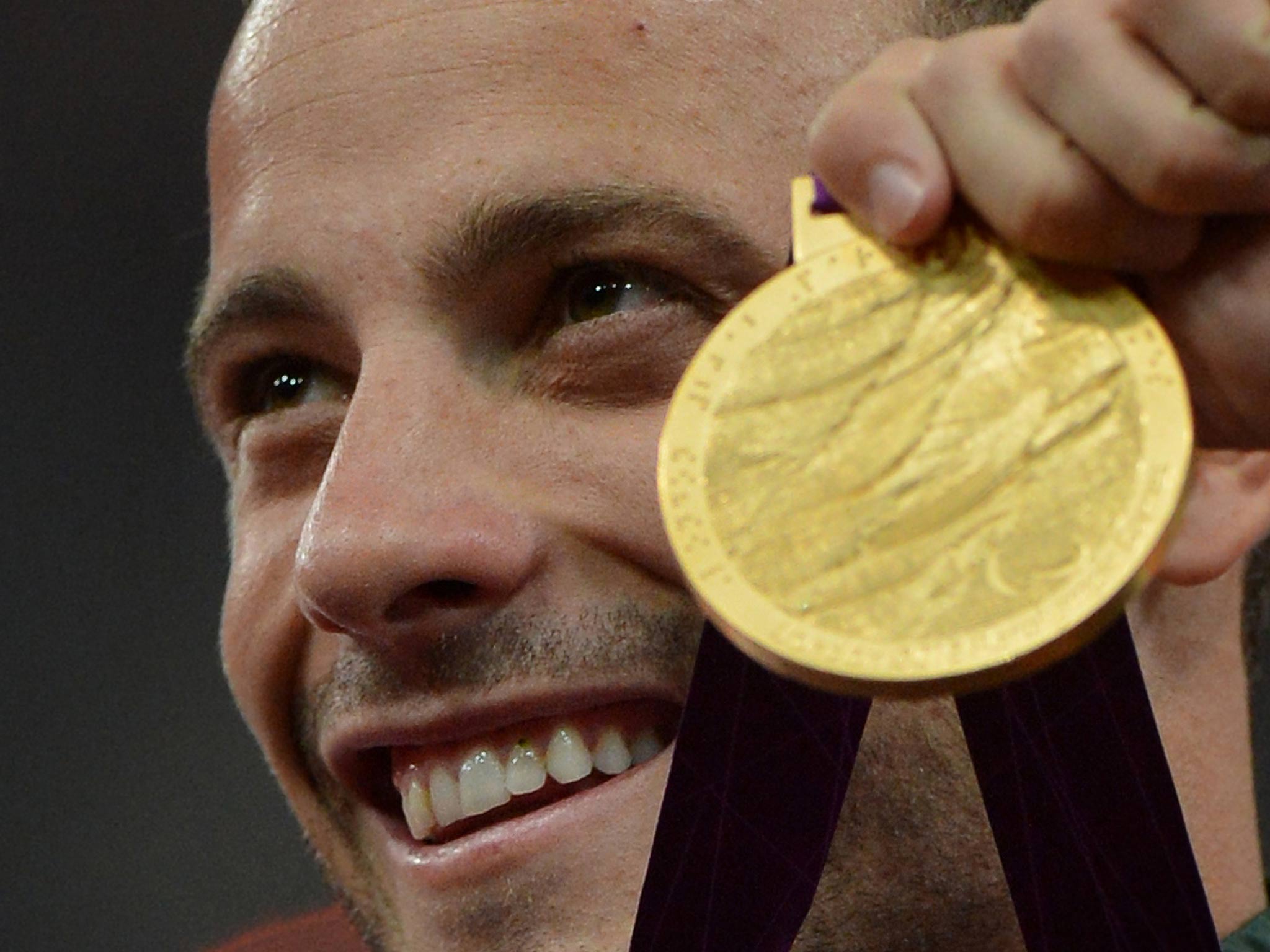 Pistorius celebrates with a gold medal at the Paralympics