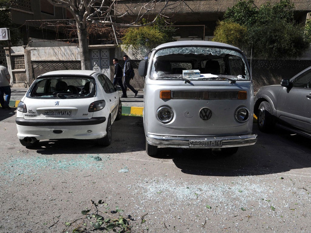 Damaged cars in front of the Tishrin Stadium