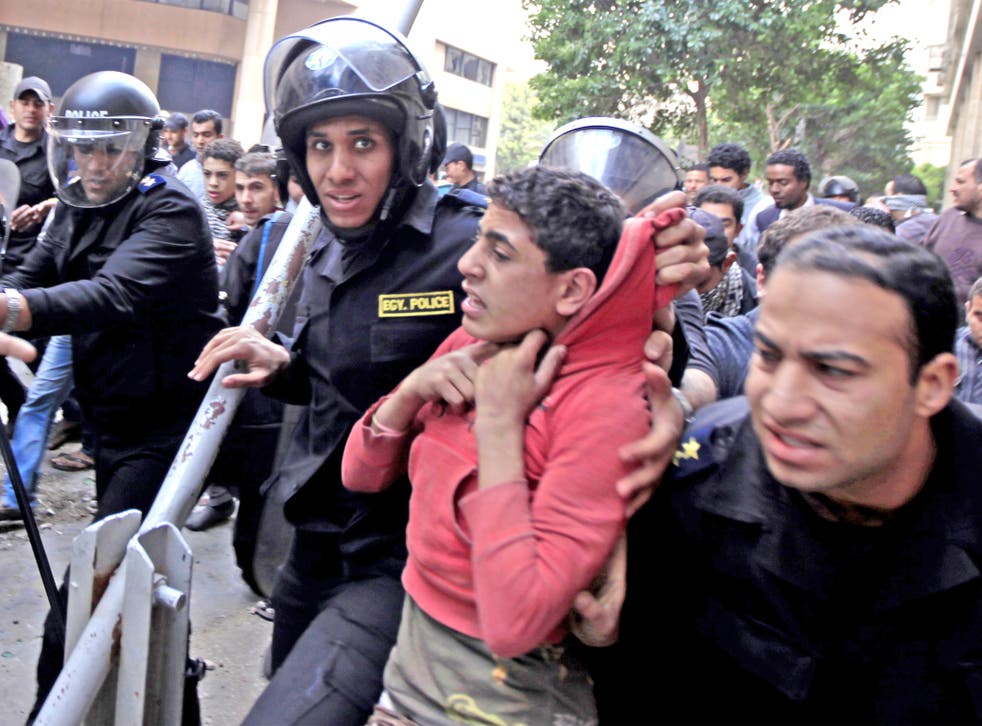 Egyptian riot police arrest a young man during clashes with protesters at a demonstration near Tahrir Square, Cairo, earlier this year