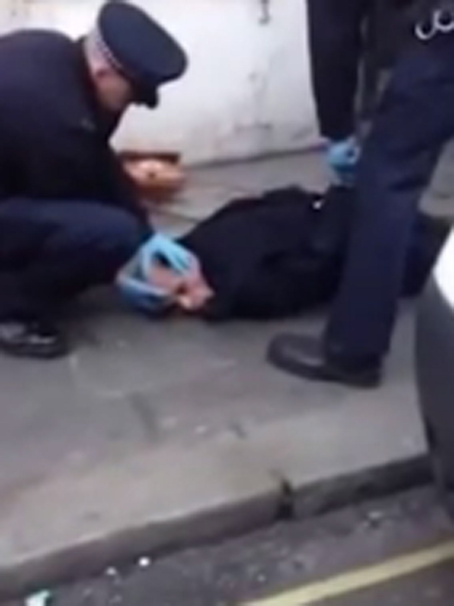 A shot from the video showing the transgendered woman being held down by police