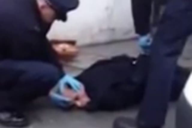 A shot from the video showing the transgendered woman being held down by police 