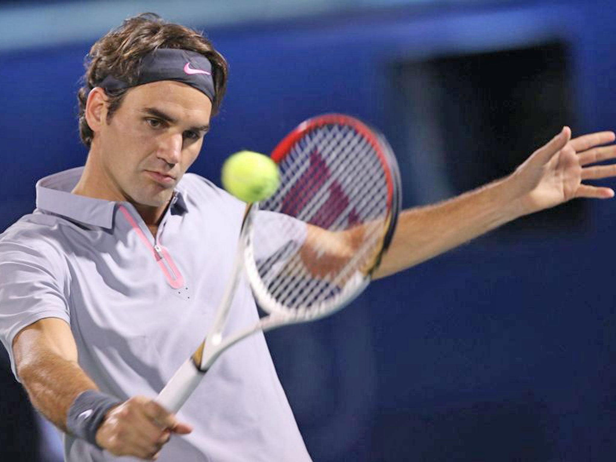 Roger Federer of Switzerland returns the ball to Tunisian Malek Jaziri