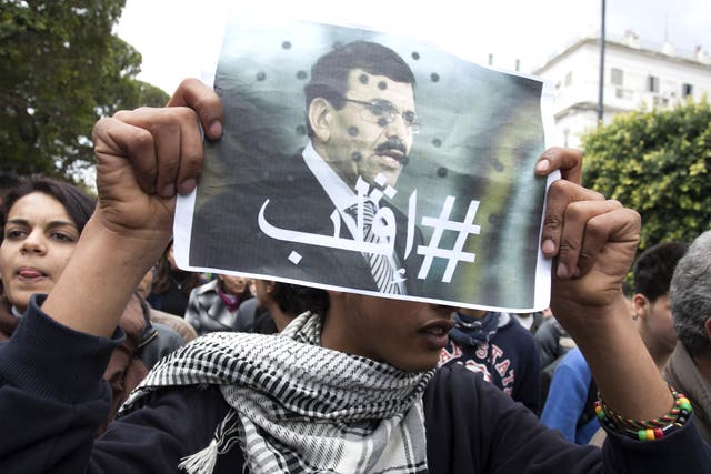 Protesters hold aloft posters of Chokri Belaid who was shot dead outside his home