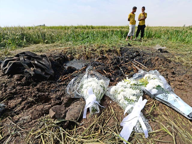 Egyptians stand by the site where a hot air balloon exploded and plunged to earth