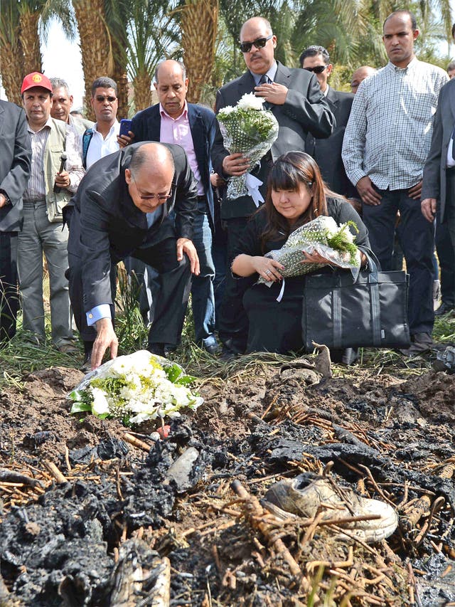 Luxor Governor Ezzat Saad lays flowers for the victims