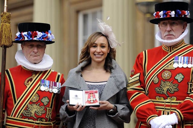Jessica Ennis poses with members of the Yeoman of the Guard after she received her Commander of the British Empire (CBE) medal from the Queen