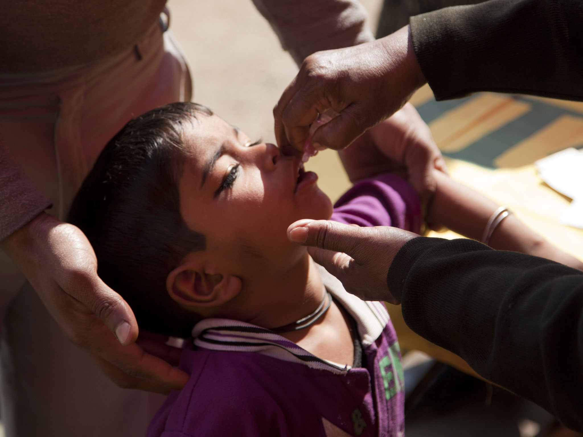 A child is given two drops of a vaccine in Delhi