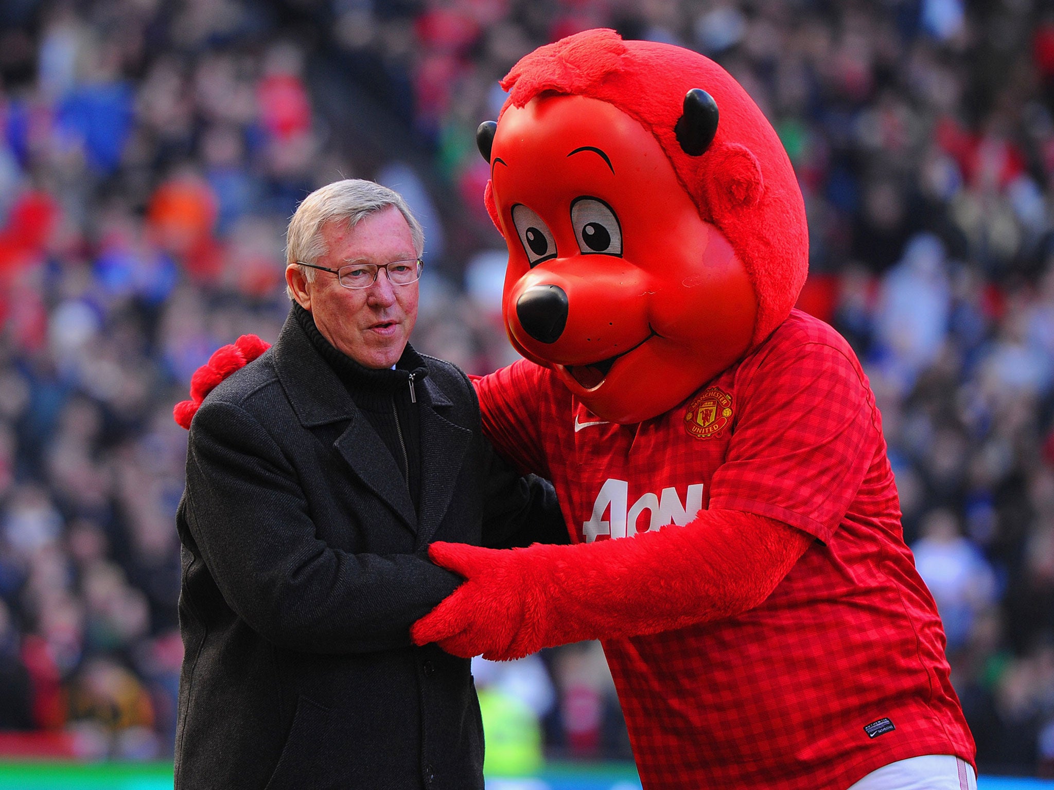 Manchester United manager Sir Alex Ferguson is greeted my 'Fred the Red'