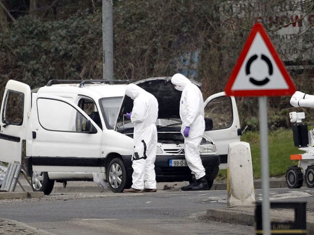Police forensic officers examine a car in which four mortar rounds were found in Londonderry