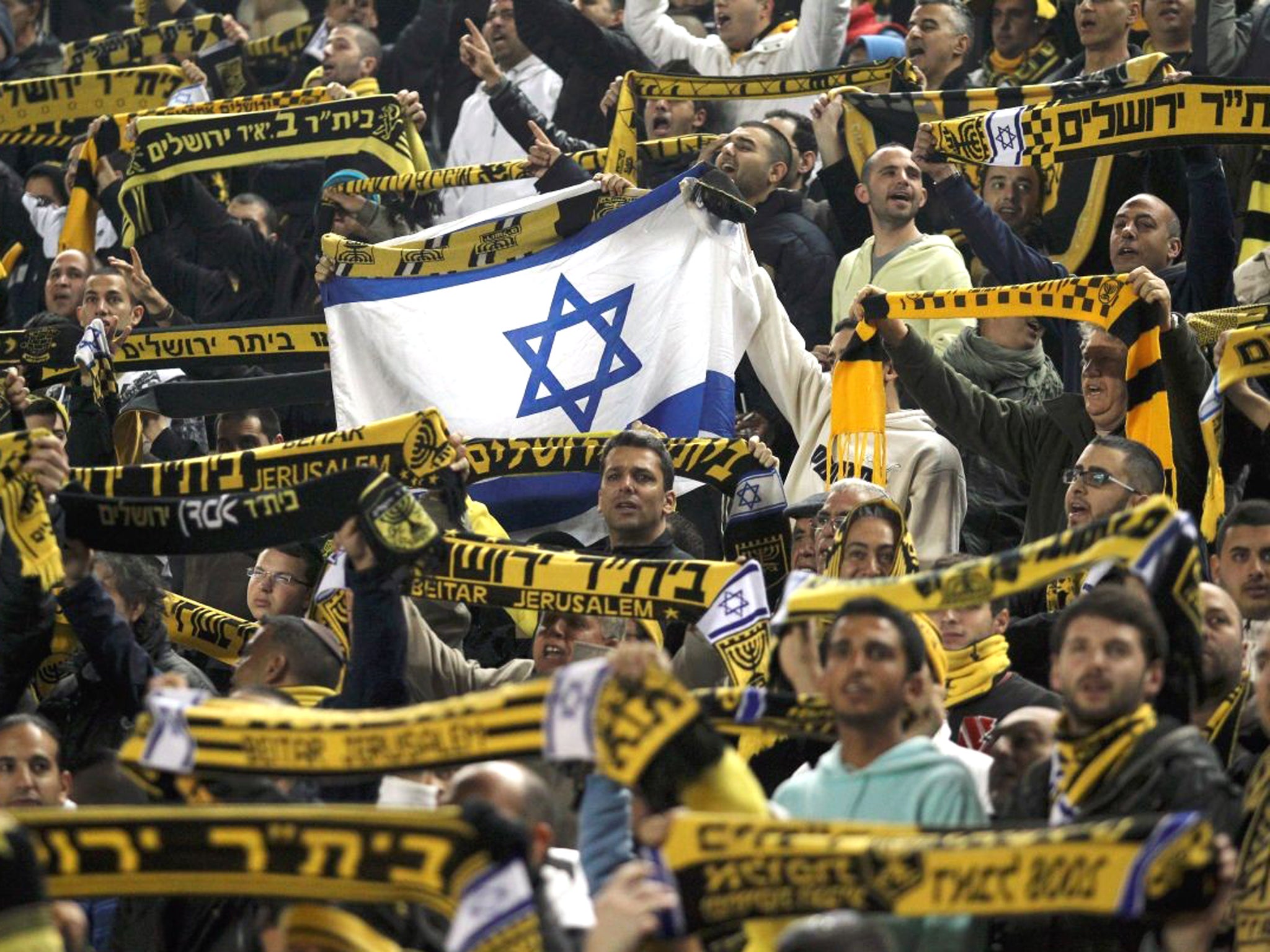 Beitar Jerusalem's supporters chant slogans during an Israeli championship football match