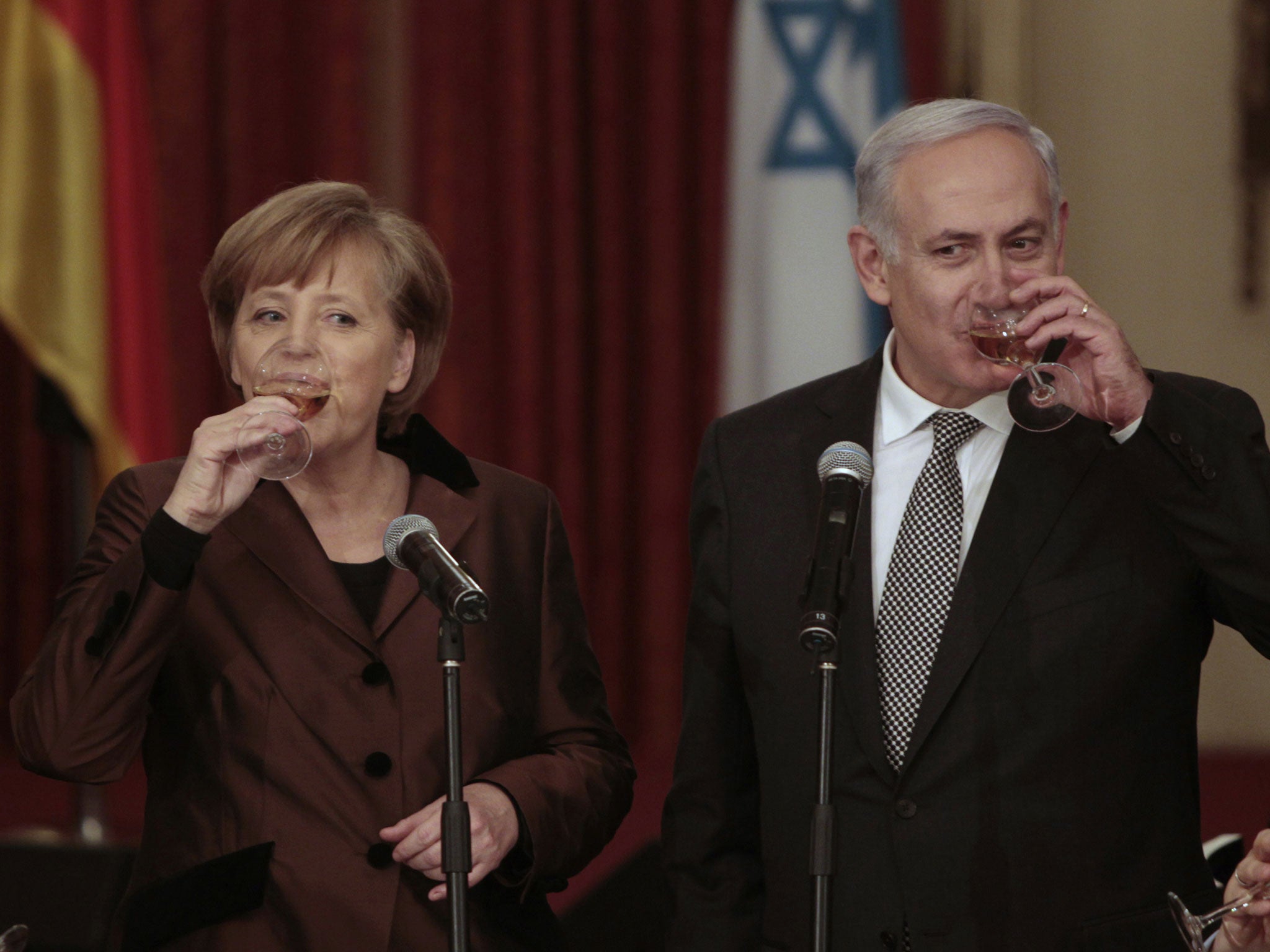 Israeli Prime Minister Benjamin Netanyahu and German Chancellor Angela Merkel take a sip after raising a toast prior to a joint dinner in Jerusalem, on January 31, 2011.