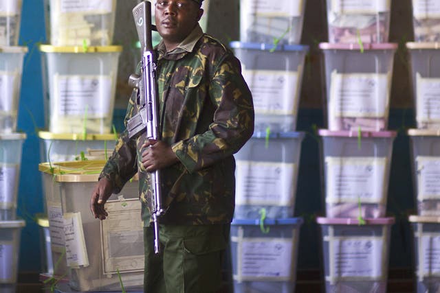 An officer of the prisons service guards ballot boxes in Nairobi