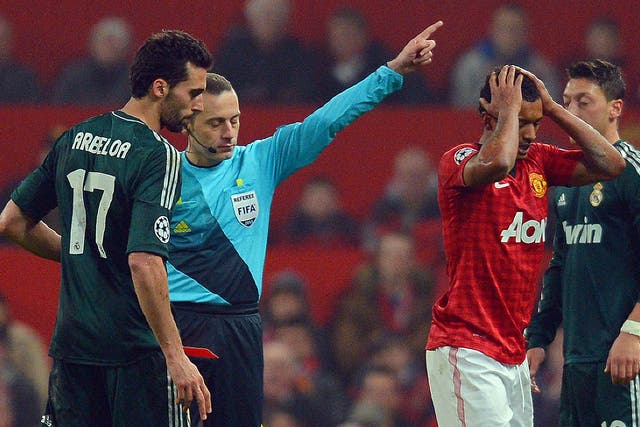 Cuneyt Cakir shows Nani a red card