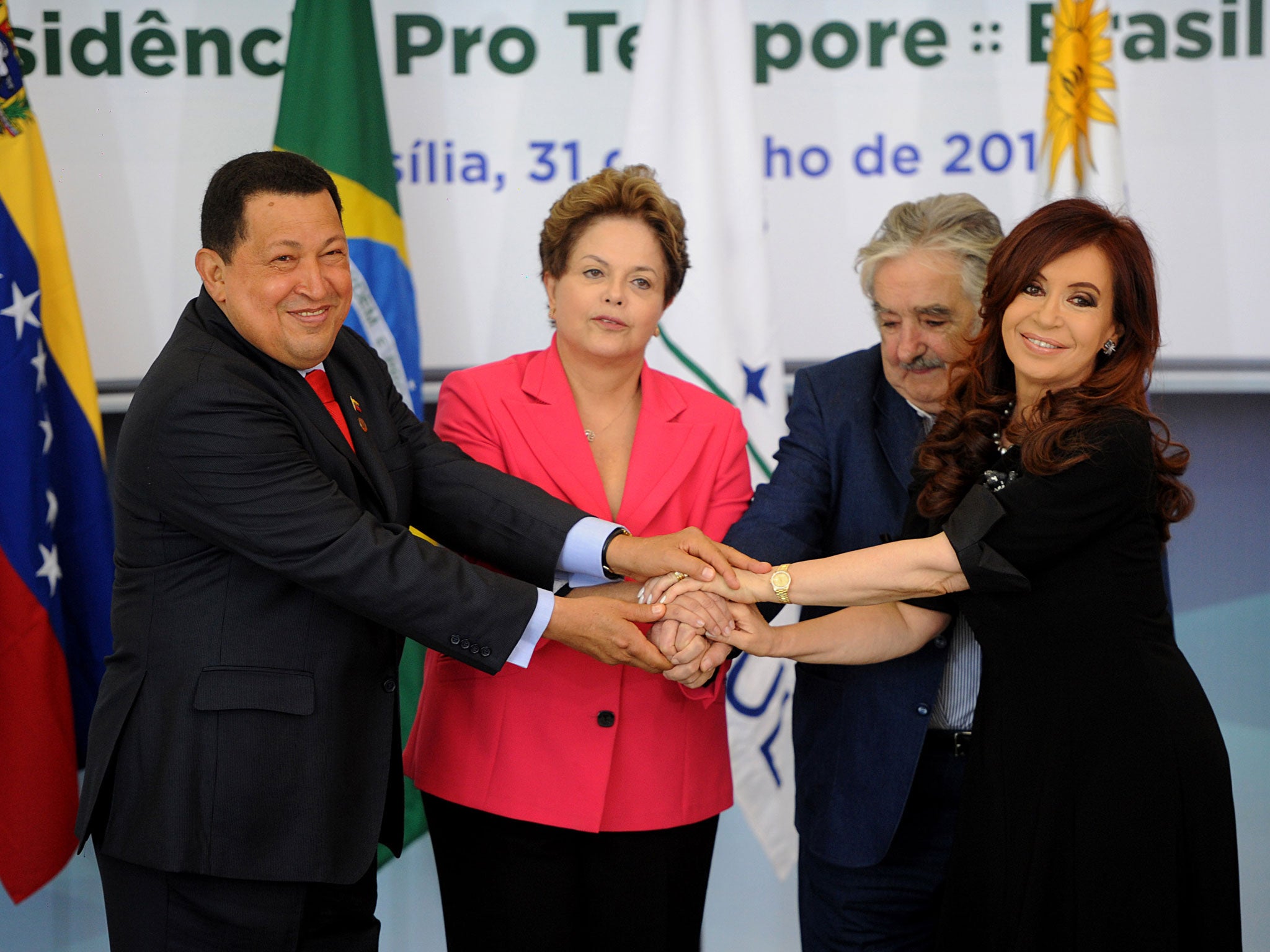 Brazilian President Dilma Rousseff (2nd-L) holds hands with the presidents of Uruguay, Jose Mujica (2nd- R), Argentina, Cristina Kirchner (R), and Venezuela, Hugo Chavez ( L), before the Mercosur Extraordinary Summit, at Planalto Palace, in Brasilia, on July 31, 2012.