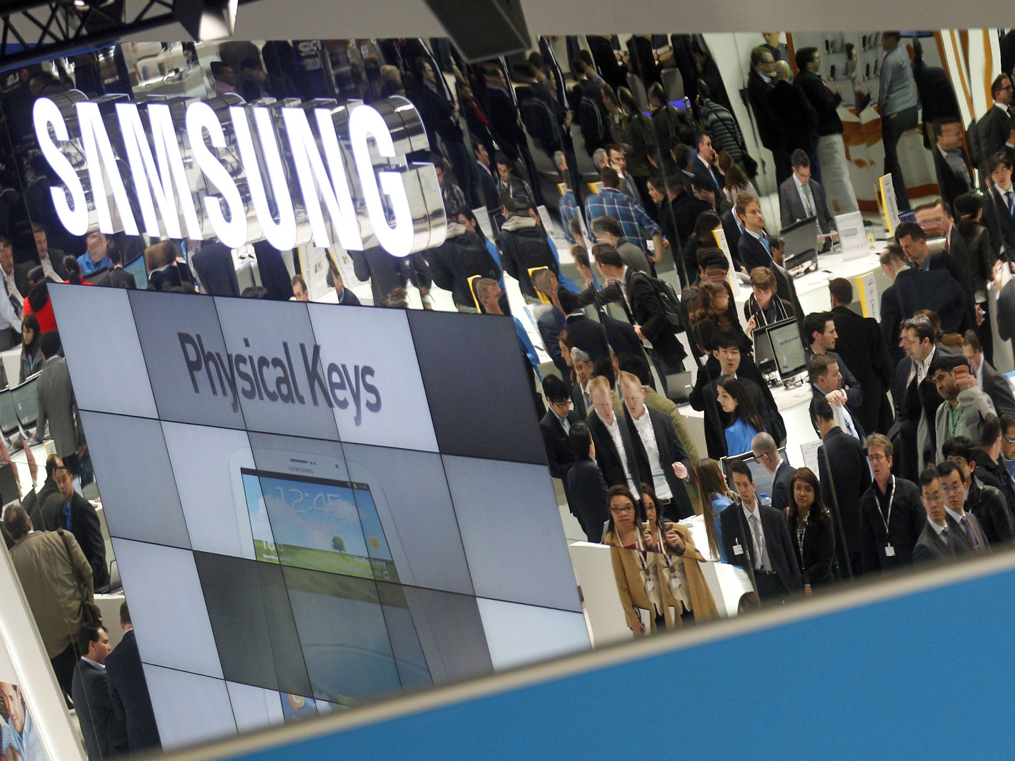 February 27, 2013: Visitors are reflected in a mirror at the Samsung stand during the Mobile World Congress at Barcelona. The GSMA Mobile World Congress, representing the interests of the worldwide mobile communications industry, takes place from February 25 to 28 in Barcelona.
