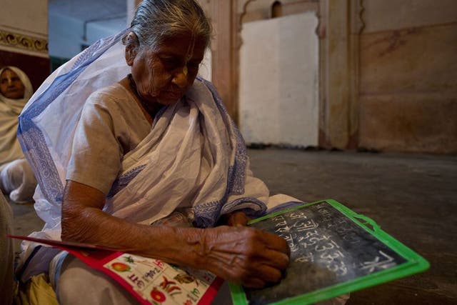 An elderly Indian widow attends a reading and writing class at the Mahila Ashram, a shelter home for widows in Vrindavan