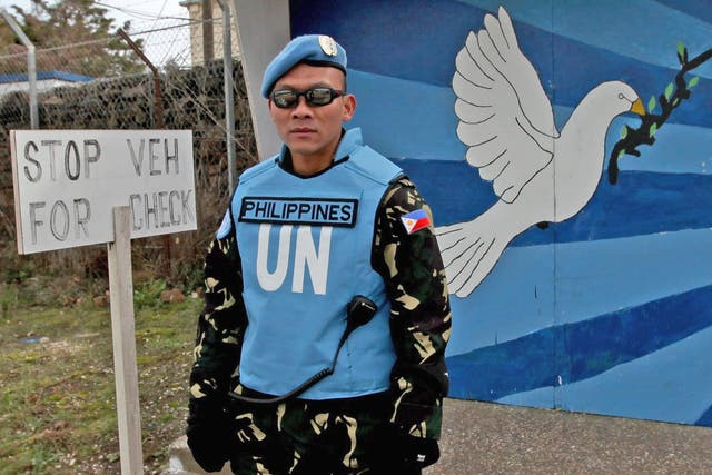 A UN Filipino solider guards the entrance to the UN headquarters near the Israeli-Syrian border