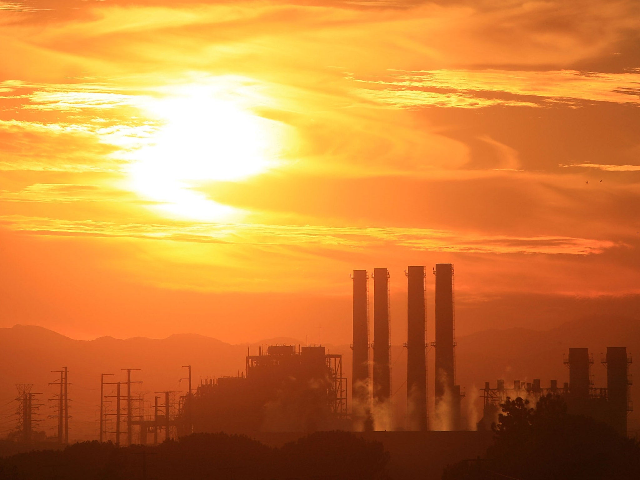 The Sun shines intensely above a power station in the Californian sky